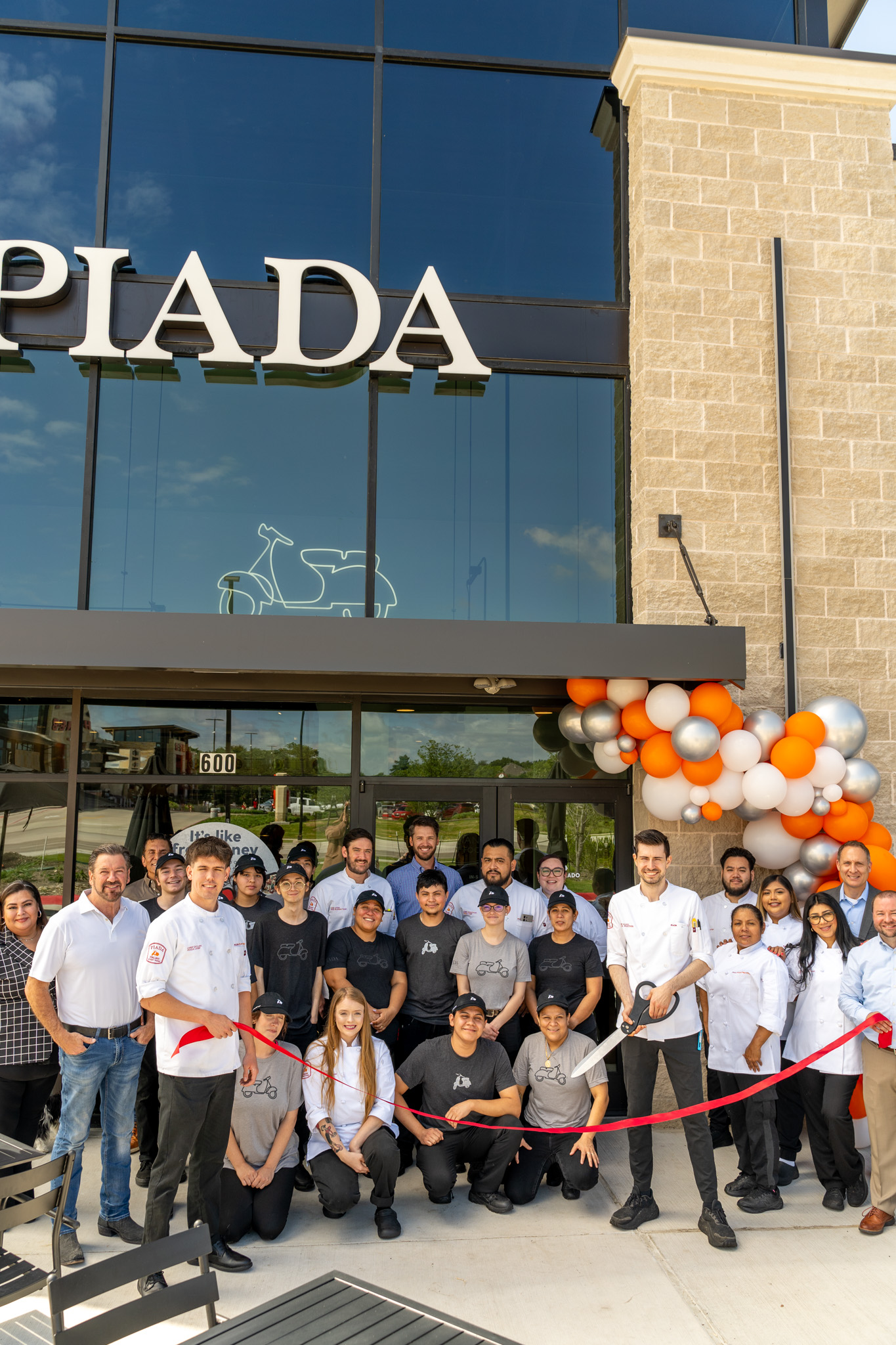 Piada team ribbon cutting at a grand opening celebration